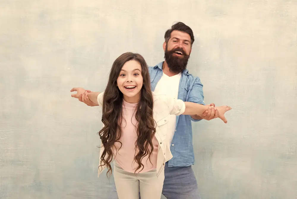 Smiling father holding hands with daughter, symbolizing strong parent-child bond after winning custody in Austin, TX