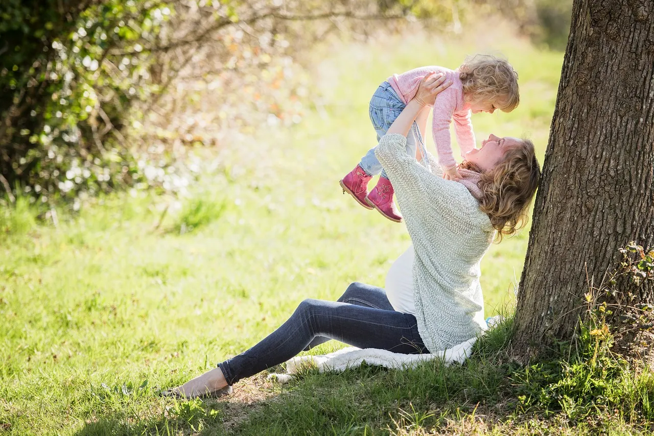 A mom playing with her child in the park.