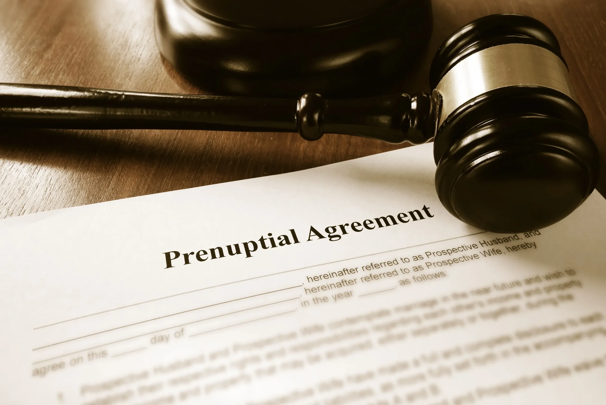 Prenuptial agreement and a gavel on a wooden desk.