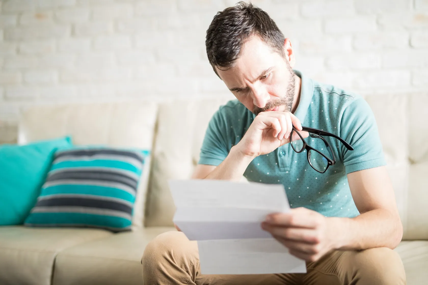 A man sits intently reading a legal document.