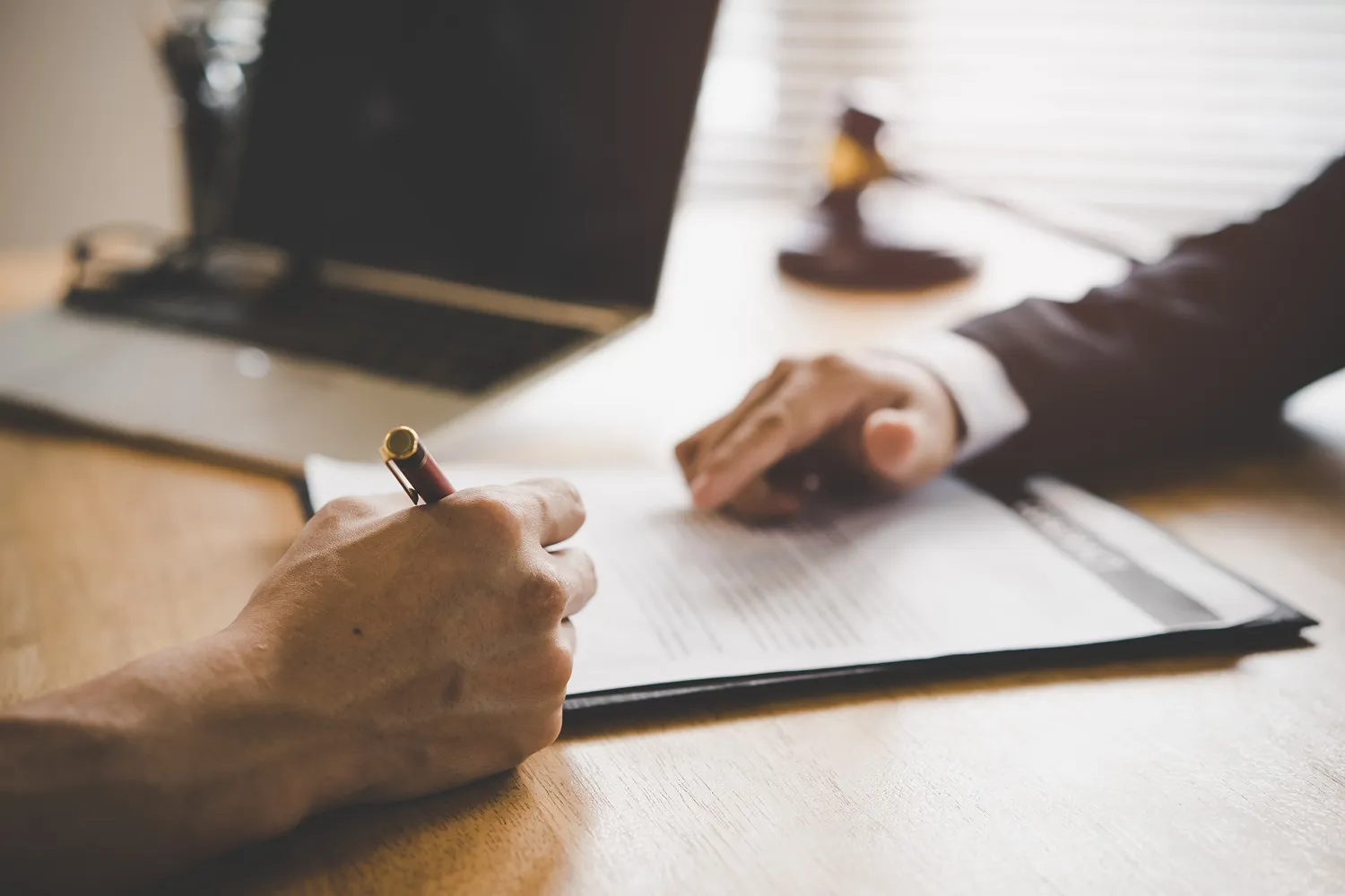 An attorney having a client sign a page.
