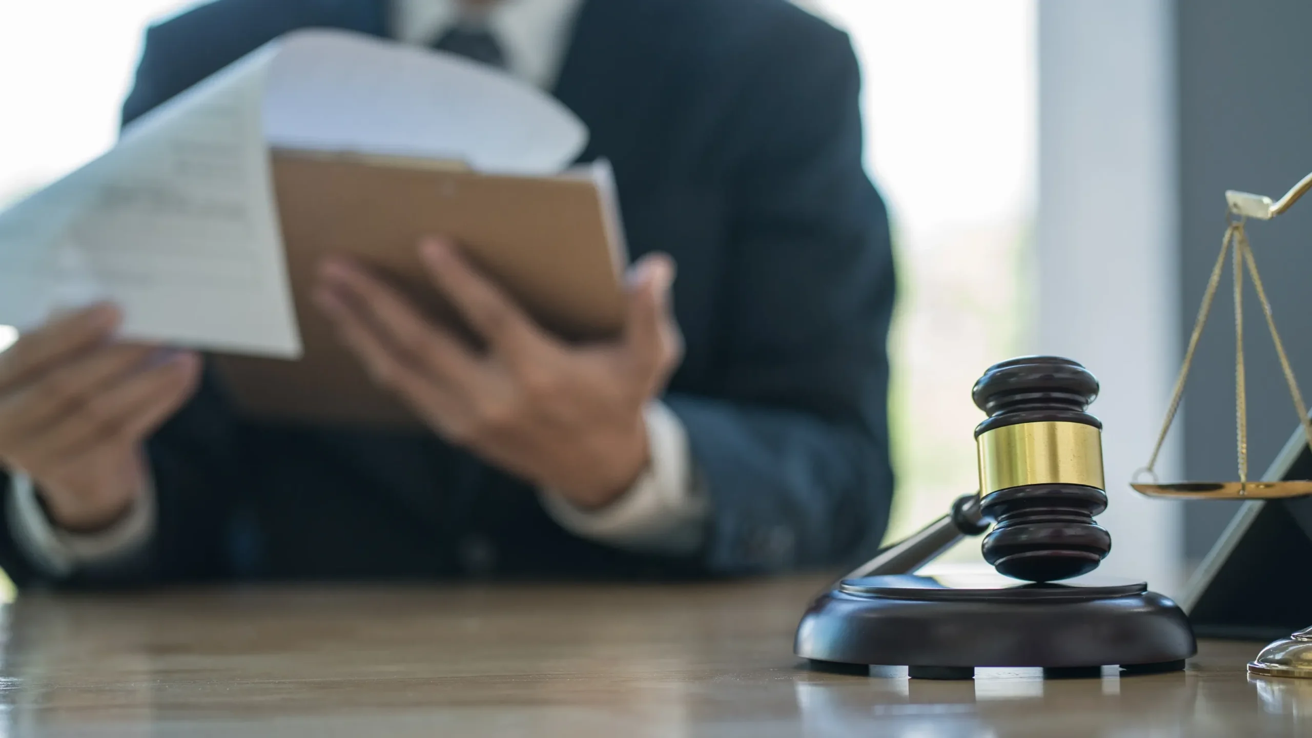 An attorney reviewing paperwork with a gavel on his desk.