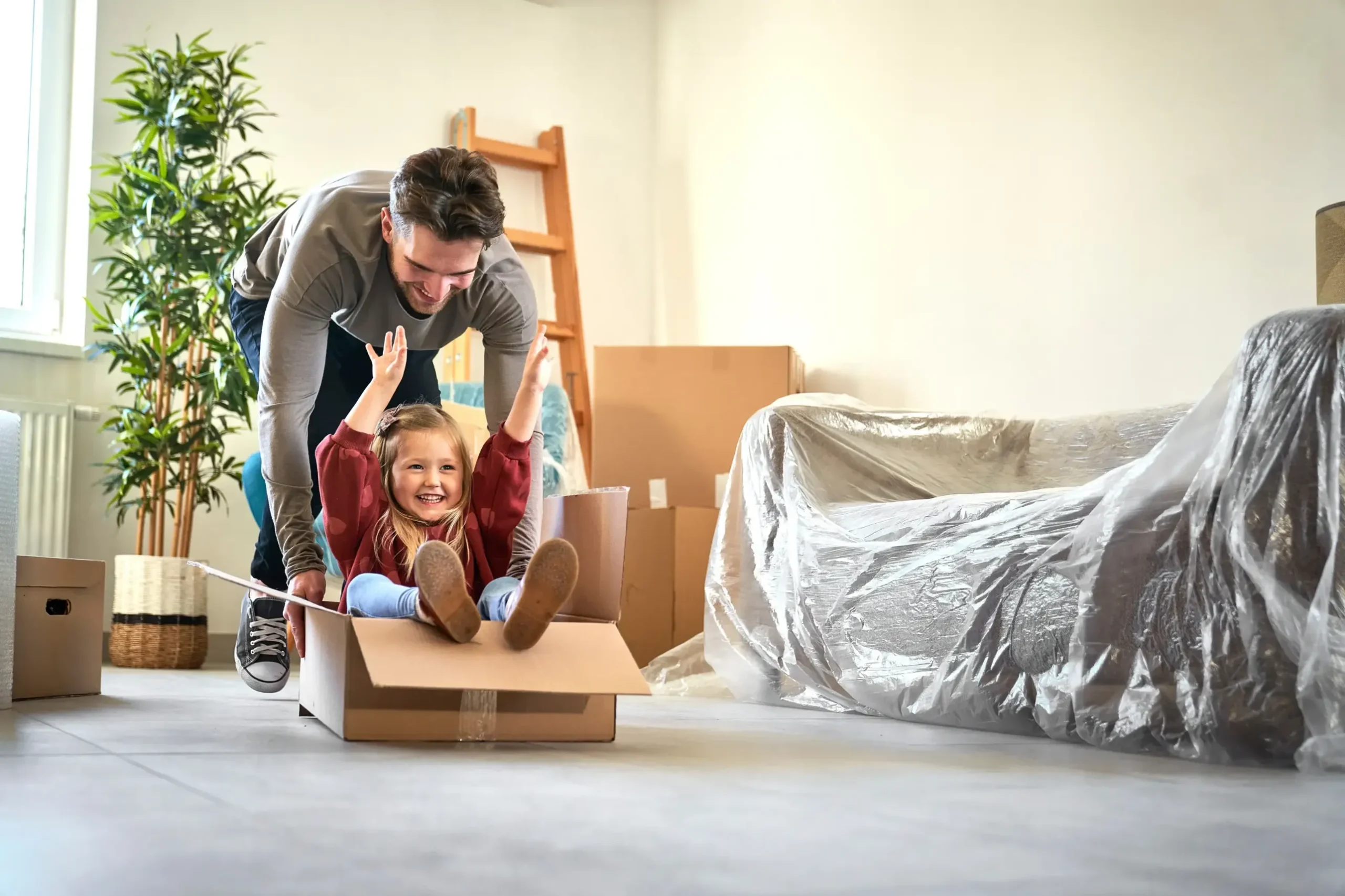 A dad playing with his daughter in a box.