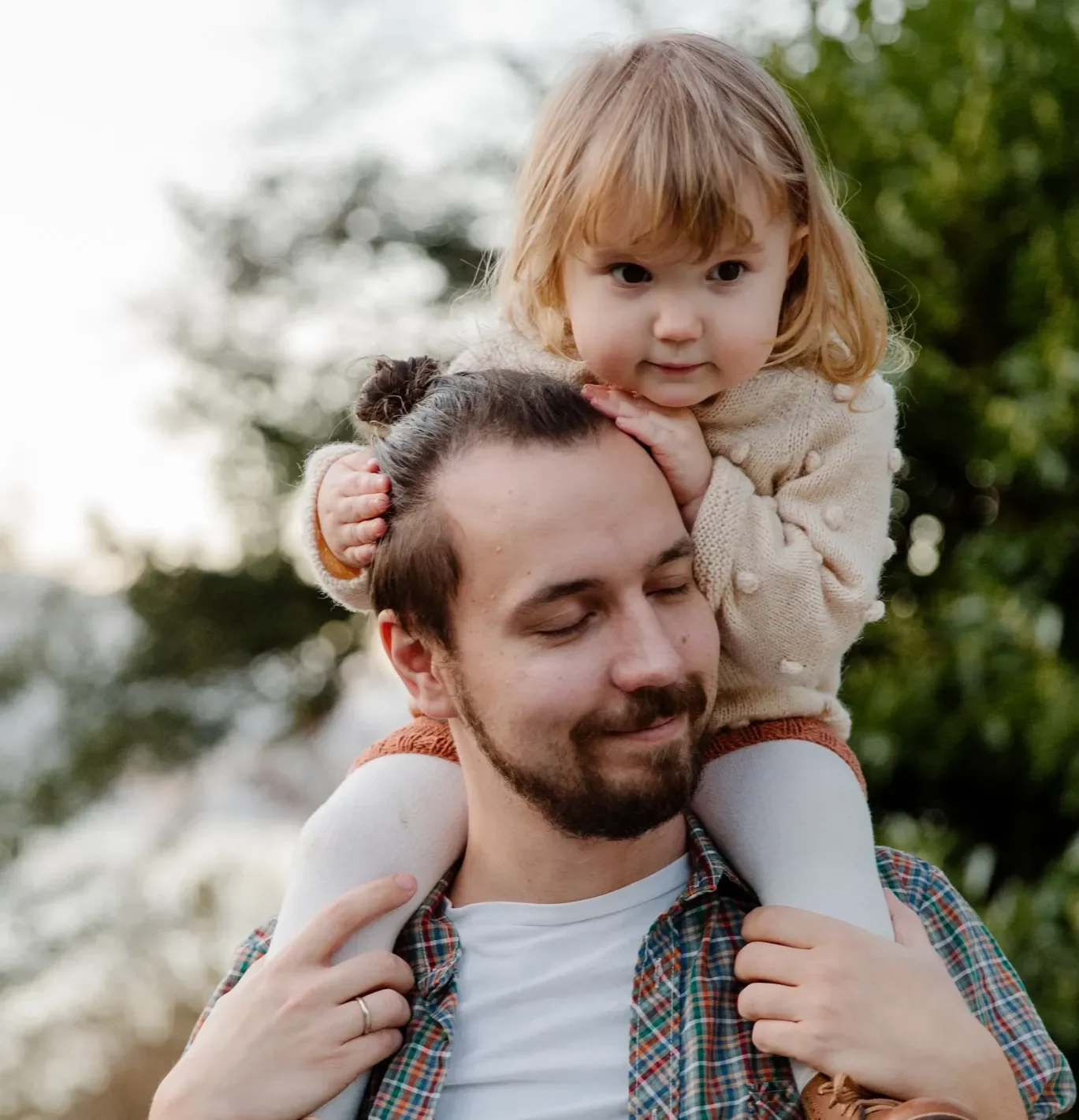 A dad with his daughter on his shoulders.