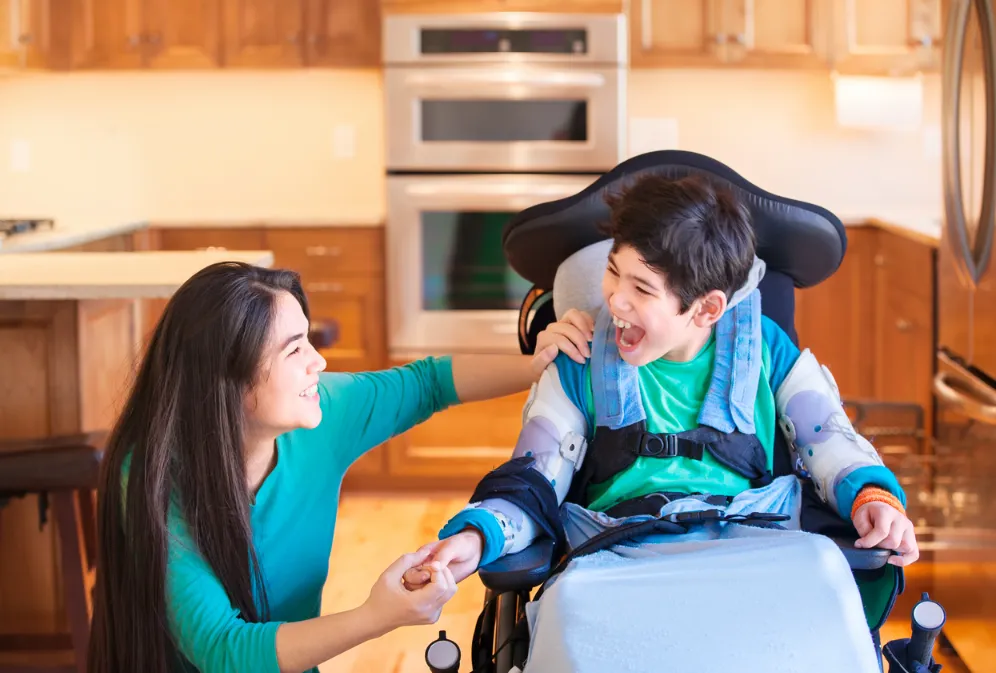 A mom smiling to her son in a wheelchair.