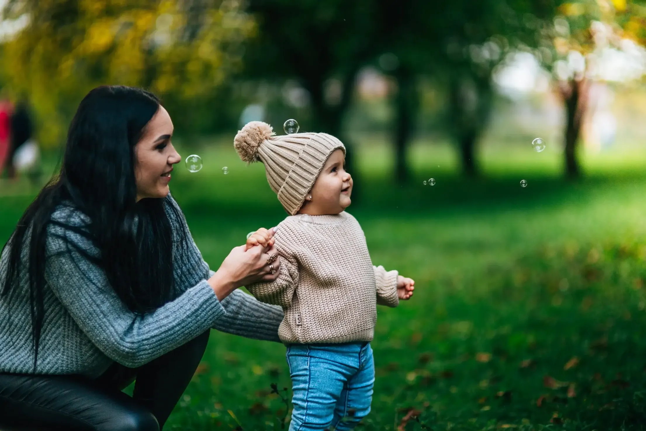 A mom playing with her baby and bubbles.