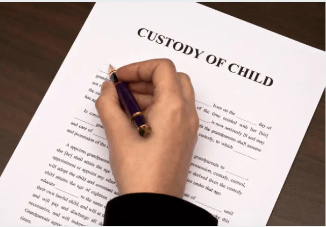 A woman writing on a contract that says custody of child.