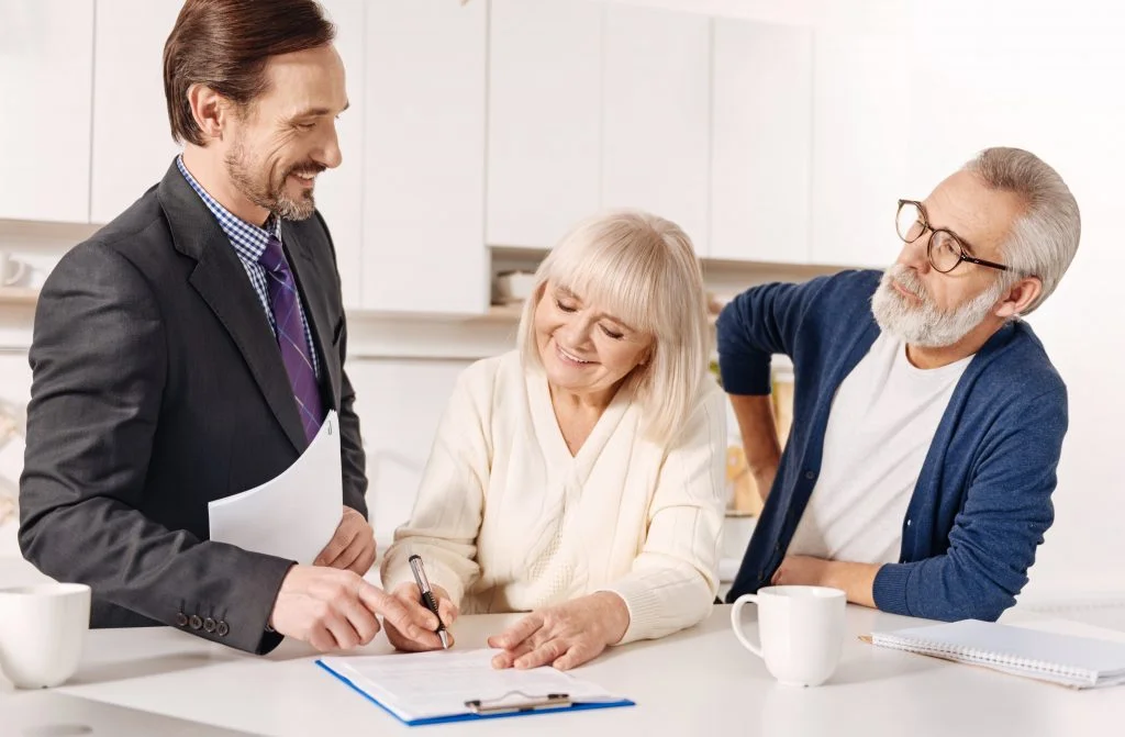 Couple signing a postnuptial agreement at a lawyers office.