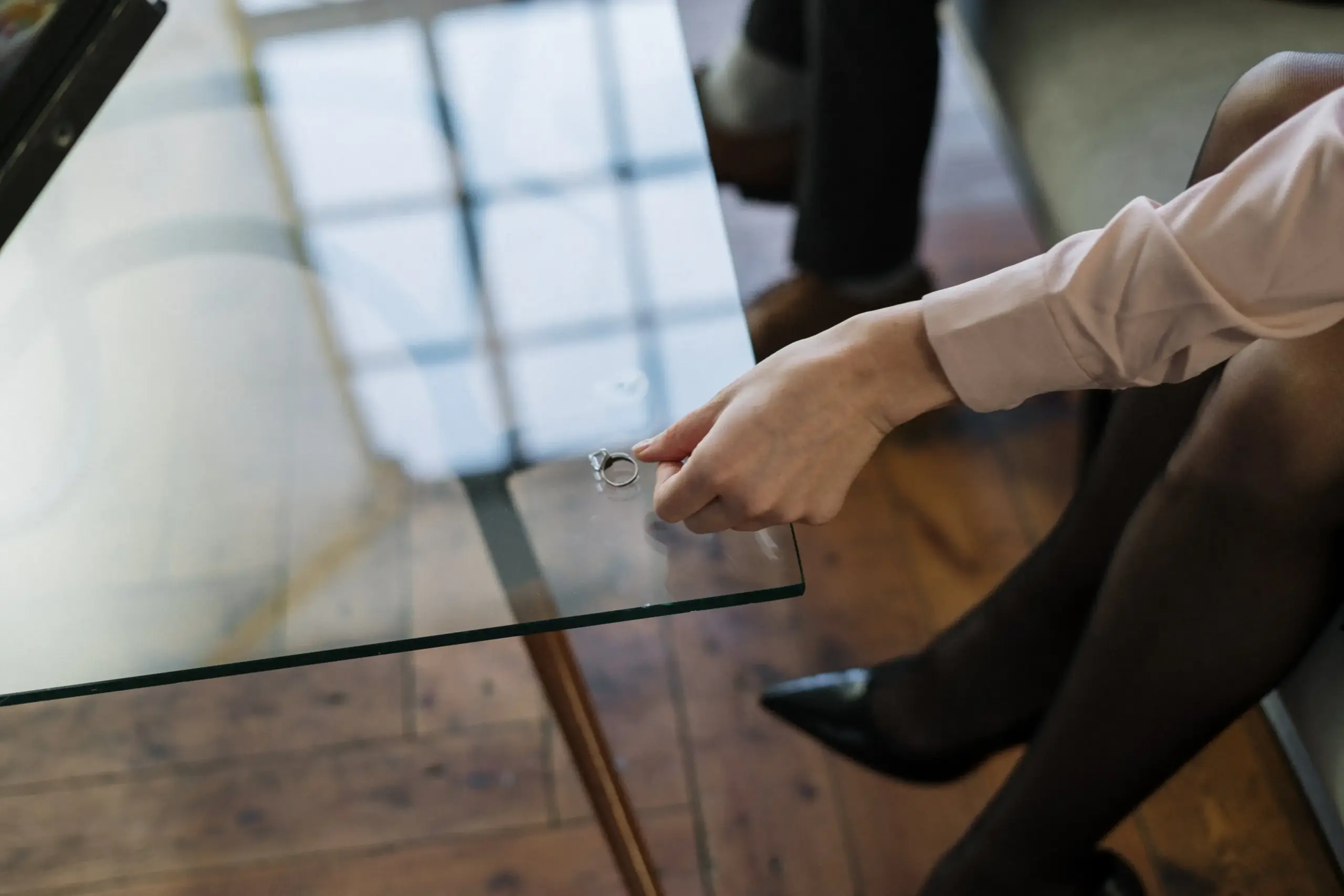 Side view of woman laying her ring on a table talking to an Austin Divorce Attorney.