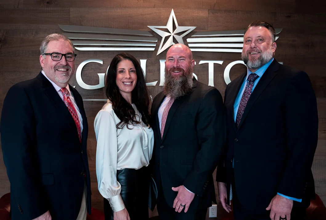 The attorneys at Eggleston Law Firm standing in front of the company sign.