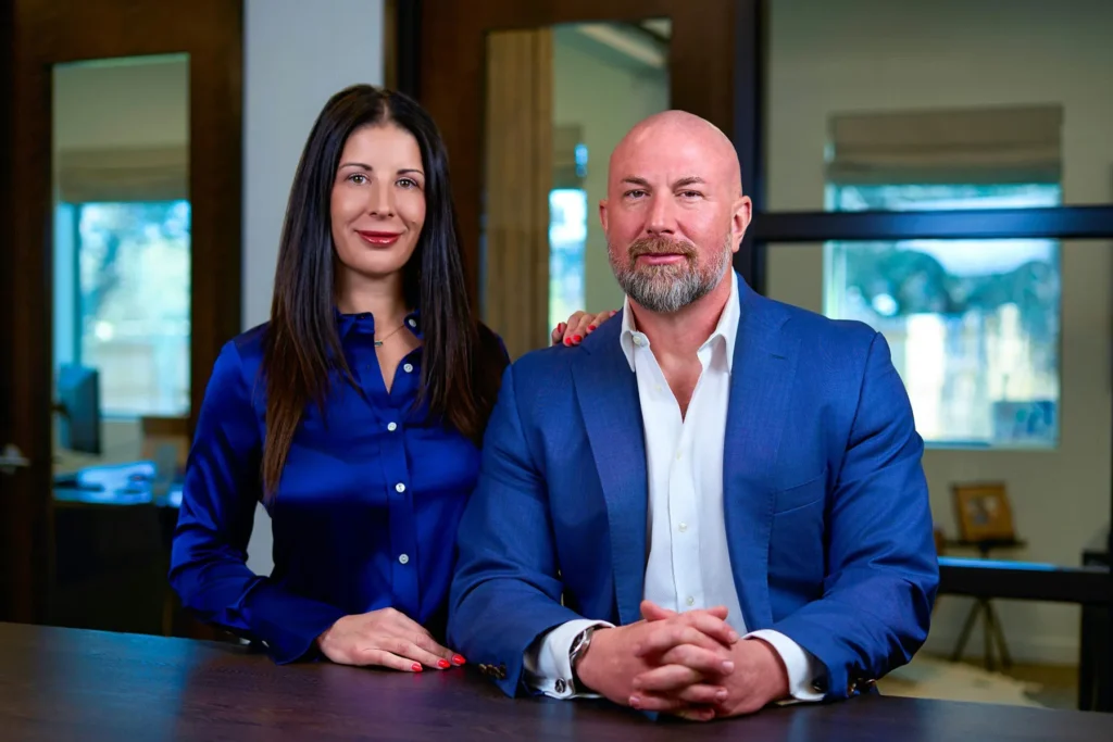 Janice and Bryan Eggleston Family Law Attorneys standing at desk in their Austin TX office..